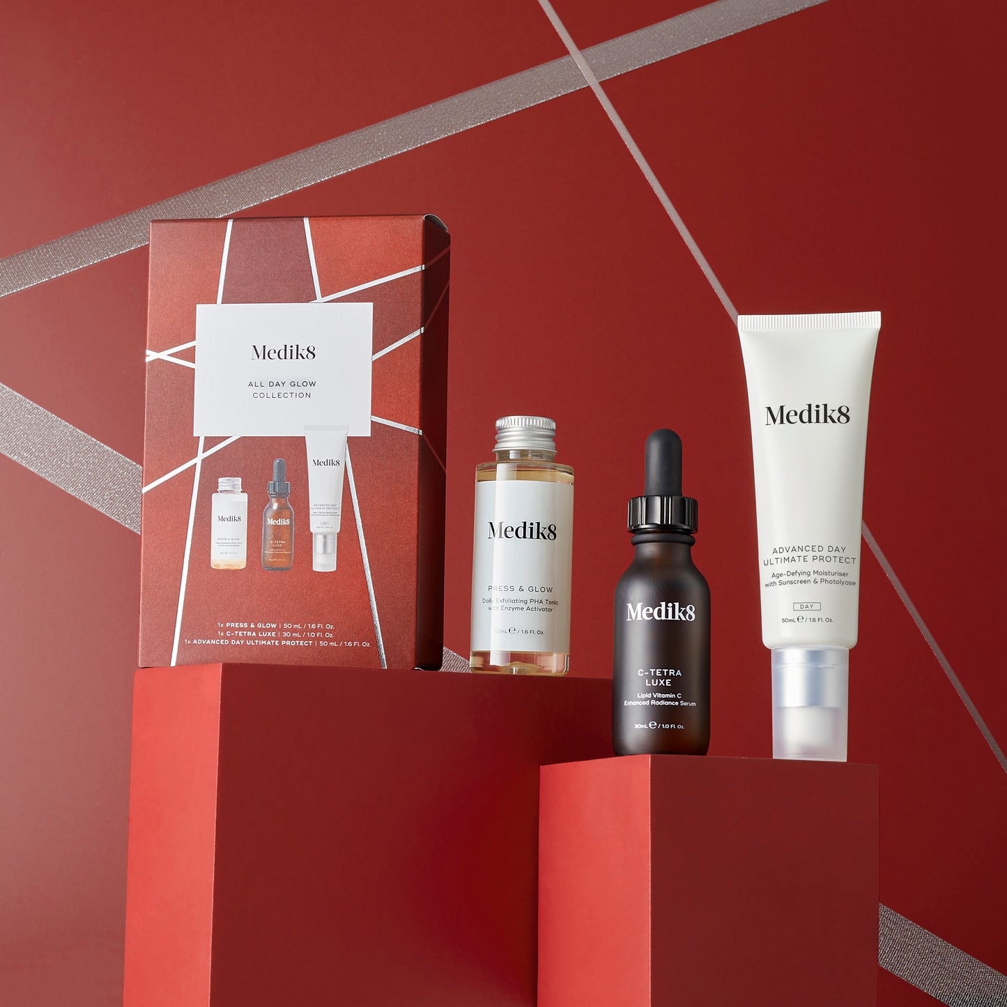 Medik8 All Day Glow Collection, presented in a sleek red gift box, includes C-Tetra Luxe (30ml dropper bottle), Advanced Day Total Protect (50ml tube), and Press & Glow (50ml bottle).