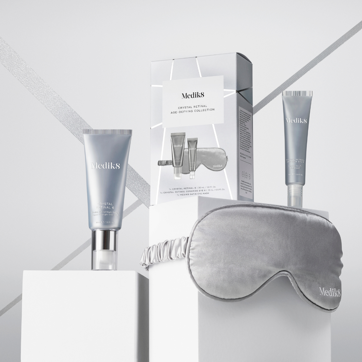 Medik8 Crystal Retinal Age-Defying Collection contains Crystal Retinal 6 30ml, Crystal Retinal Ceramide Eye 6 15ml,each product housed in a metallic silver airless pump bottle, and metallic silver Satin eye mask.